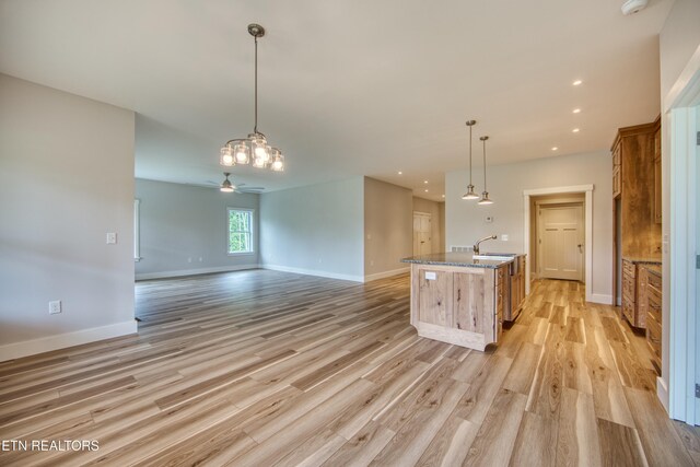 760 Rockview Rd, Jamestown, TN 38556 - kitchen with light wood finished floors, brown cabinets, open floor plan, dark stone counters, and a ceiling fan
