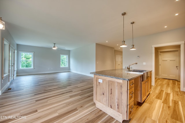 760 Rockview Rd, Jamestown, TN 38556 - kitchen with light wood-type flooring, ceiling fan, an island with sink, dark stone countertops, and open floor plan