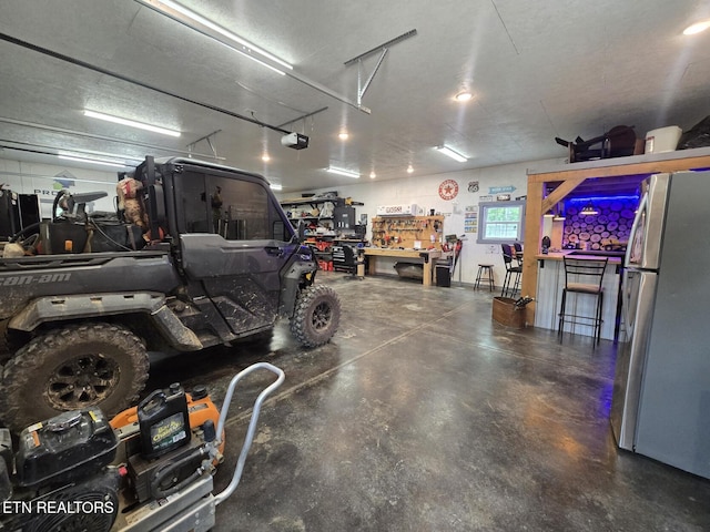 669 Crooked Branch Pvt Rd, Huntsville, TN 37756 - garage with freestanding refrigerator, a workshop area, and a garage door opener