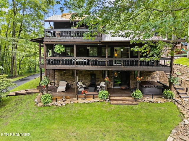 573 Hilltop Dr, Jacksboro, TN 37757 - rear view of property with a hot tub, a wooden deck, a yard, a metal roof, and a patio