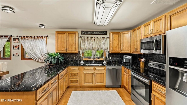 573 Hilltop Dr, Jacksboro, TN 37757 - kitchen featuring stainless steel appliances, light wood-type flooring, tasteful backsplash, and a peninsula
