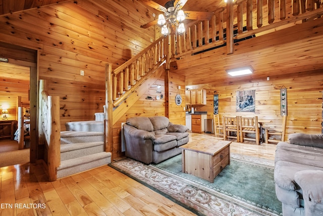 1930 Orchard Dr, Sevierville, TN 37876 - living room featuring stairway, wooden walls, a ceiling fan, and light wood-style flooring