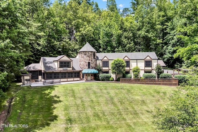 3950 Castle Rd, Gatlinburg, TN 37738 - view of front of property with a sunroom, a front yard, a patio, and stucco siding