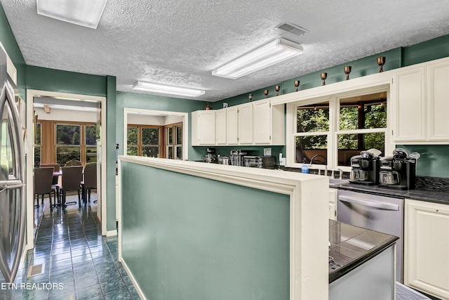 3950 Castle Rd, Gatlinburg, TN 37738 - kitchen with white cabinets, plenty of natural light, a textured ceiling, and dark countertops