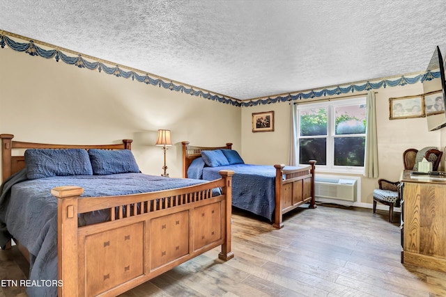 3950 Castle Rd, Gatlinburg, TN 37738 - bedroom featuring hardwood / wood-style flooring, a textured ceiling, and an AC wall unit