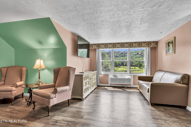 3950 Castle Rd, Gatlinburg, TN 37738 - living area featuring hardwood / wood-style flooring, a textured ceiling, and an AC wall unit