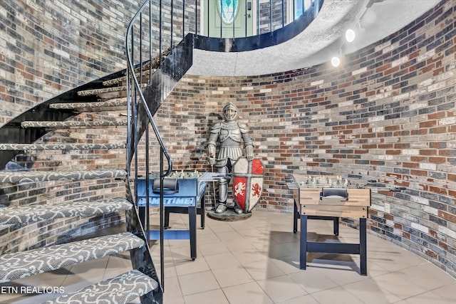 3950 Castle Rd, Gatlinburg, TN 37738 - stairs with brick wall, a high ceiling, and tile patterned flooring