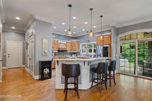 203 Georgian Ln, Sevierville, TN 37862 - kitchen featuring stainless steel fridge with ice dispenser, light stone counters, tasteful backsplash, light wood-type flooring, and a kitchen bar