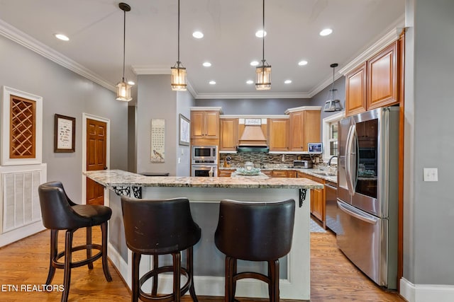 203 Georgian Ln, Sevierville, TN 37862 - kitchen with stainless steel appliances, premium range hood, light stone countertops, a center island, and backsplash