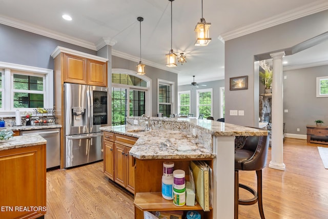 203 Georgian Ln, Sevierville, TN 37862 - kitchen with appliances with stainless steel finishes, decorative columns, a kitchen bar, open shelves, and light wood-type flooring