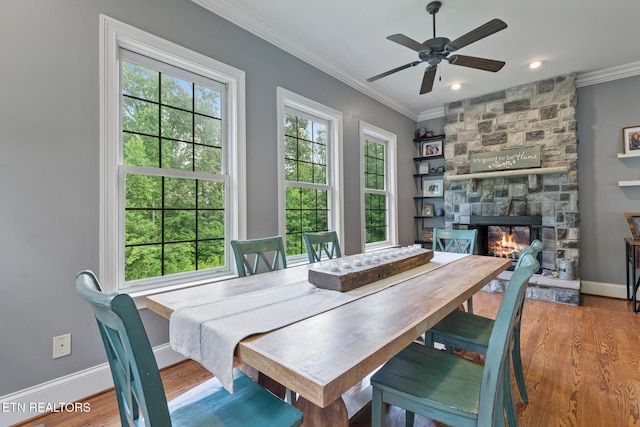 203 Georgian Ln, Sevierville, TN 37862 - dining area with plenty of natural light, ornamental molding, a stone fireplace, a ceiling fan, and wood finished floors
