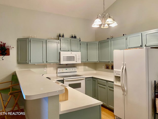 209 Commander Way, Knoxville, TN 37934 - kitchen featuring white appliances, a peninsula, a chandelier, light countertops, and vaulted ceiling