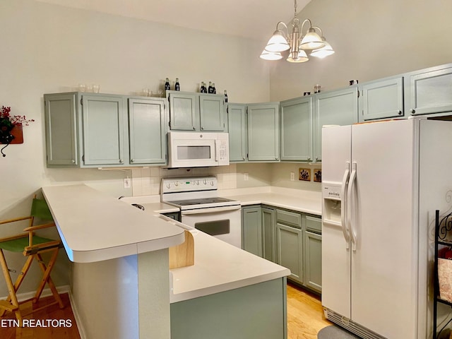 209 Commander Way, Knoxville, TN 37934 - kitchen with white appliances, a peninsula, a chandelier, light wood-type flooring, and a kitchen breakfast bar