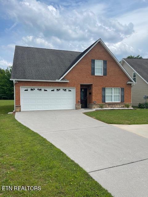 109 Abbott Rd, Lenoir City, TN 37771 - traditional-style home with concrete driveway, brick siding, a front yard, and a garage