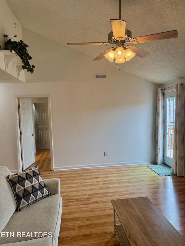 7925 Eldin Way, Powell, TN 37849 - unfurnished living room featuring vaulted ceiling, a textured ceiling, light wood-type flooring, and a ceiling fan