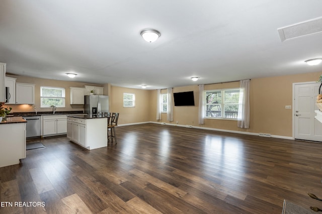 4313 Midview Ln, Knoxville, TN 37938 - kitchen featuring stainless steel appliances, a breakfast bar, open floor plan, dark countertops, and dark wood finished floors