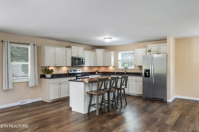 4313 Midview Ln, Knoxville, TN 37938 - kitchen featuring stainless steel appliances, dark countertops, a kitchen island, and white cabinets