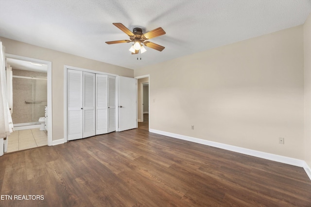 374 Farmer Hollow Rd, Clinton, TN 37716 - unfurnished bedroom with dark wood-style floors, a closet, connected bathroom, and a ceiling fan