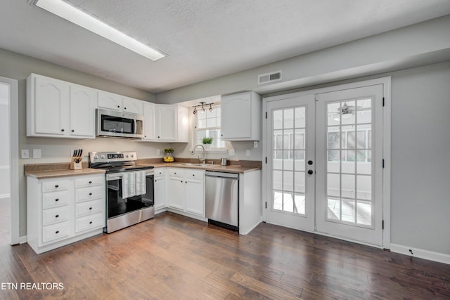 4004 Abercorn Rd, Knoxville, TN 37921 - kitchen featuring appliances with stainless steel finishes, white cabinetry, dark wood finished floors, french doors, and a textured ceiling