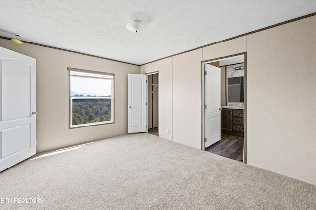 750 Bethlehem Rd, Lafollette, TN 37766 - unfurnished bedroom featuring carpet flooring, crown molding, a textured ceiling, ensuite bath, and a closet