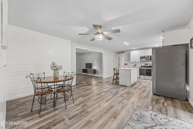 3408 Hackberry Rd, Knoxville, TN 37931 - kitchen with stainless steel appliances, a ceiling fan, white cabinetry, light countertops, and a breakfast bar
