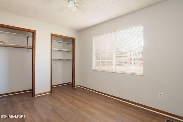 517 Bowman Bend Rd, Harriman, TN 37748 - unfurnished bedroom with dark wood-style flooring, multiple windows, a textured ceiling, a ceiling fan, and a closet