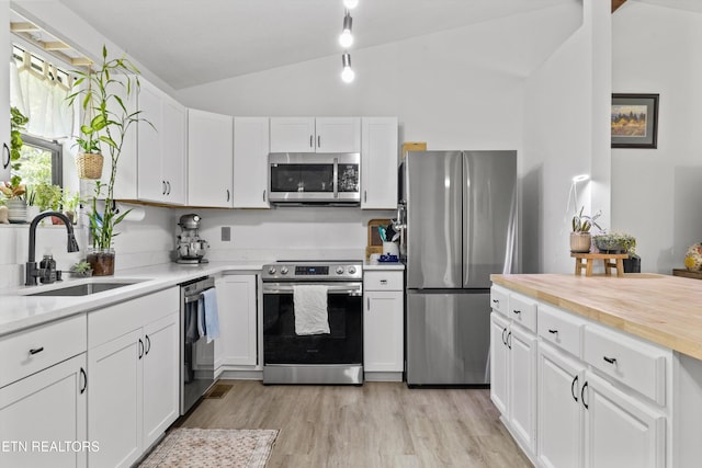 3123 Valemont Dr, Maryville, TN 37803 - kitchen featuring appliances with stainless steel finishes, vaulted ceiling, white cabinets, light wood finished floors, and butcher block counters