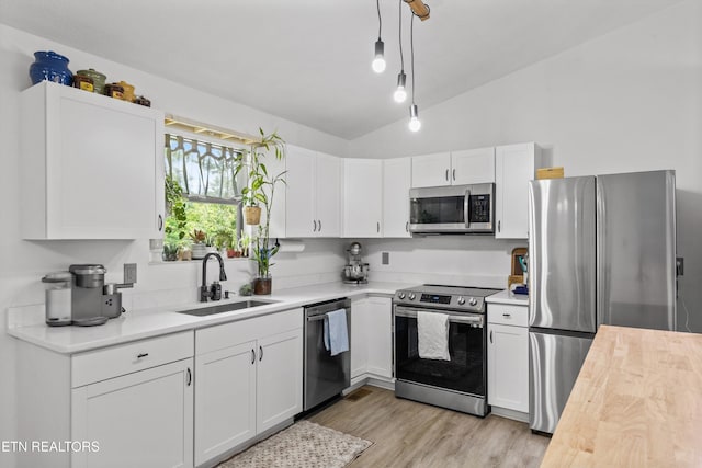 3123 Valemont Dr, Maryville, TN 37803 - kitchen with appliances with stainless steel finishes, vaulted ceiling, white cabinetry, hanging light fixtures, and light wood-type flooring