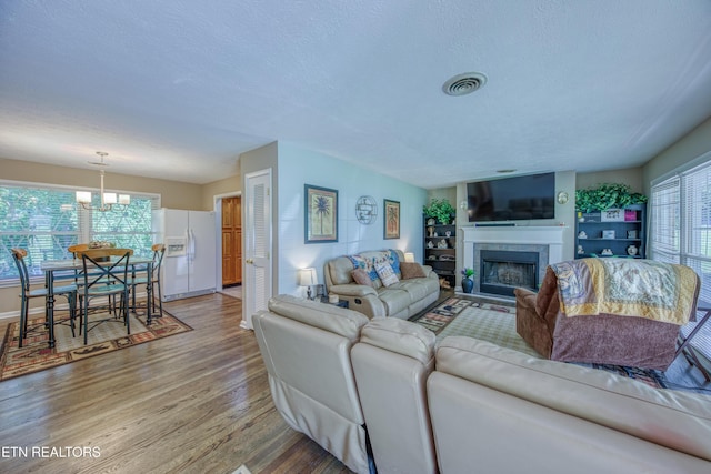 109 Wedgewood Rd, Oak Ridge, TN 37830 - living area with light wood finished floors, a fireplace, a textured ceiling, and a chandelier