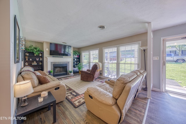 109 Wedgewood Rd, Oak Ridge, TN 37830 - living area featuring a textured ceiling, a tiled fireplace, wood finished floors, and healthy amount of natural light
