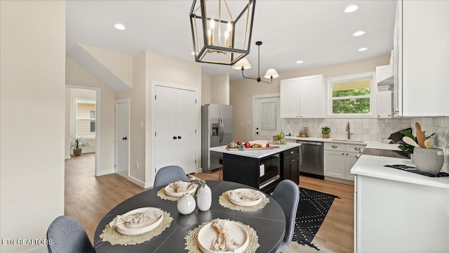 130 S Van Gilder St, Knoxville, TN 37915 - kitchen featuring stainless steel appliances, light wood-style flooring, a center island, light countertops, and decorative backsplash