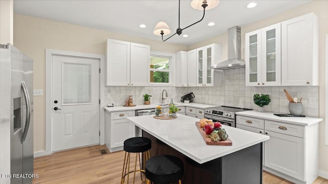 130 S Van Gilder St, Knoxville, TN 37915 - kitchen with wall chimney exhaust hood, stainless steel appliances, white cabinetry, light wood-style flooring, and recessed lighting