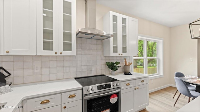 130 S Van Gilder St, Knoxville, TN 37915 - kitchen featuring electric range, wall chimney range hood, light wood-type flooring, light countertops, and white cabinetry
