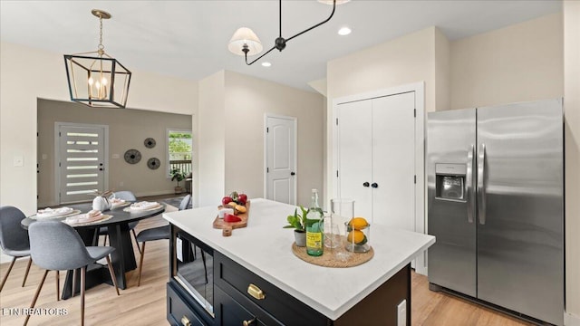 130 S Van Gilder St, Knoxville, TN 37915 - kitchen with stainless steel refrigerator with ice dispenser, a chandelier, light countertops, light wood finished floors, and pendant lighting