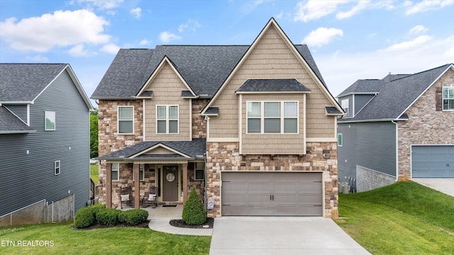 2679 Brooke Willow Blvd, Knoxville, TN 37932 - craftsman-style house featuring stone siding, driveway, a front yard, a porch, and roof with shingles