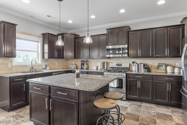 2679 Brooke Willow Blvd, Knoxville, TN 37932 - kitchen featuring appliances with stainless steel finishes, dark brown cabinets, a breakfast bar area, a center island, and light stone counters