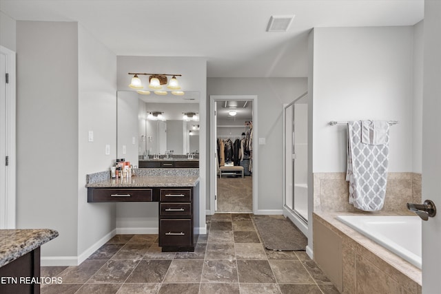 2679 Brooke Willow Blvd, Knoxville, TN 37932 - full bathroom featuring vanity, a stall shower, a garden tub, a walk in closet, and stone finish flooring