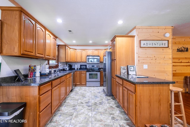 460 Red Bud Ln, Sevierville, TN 37876 - kitchen featuring appliances with stainless steel finishes, a kitchen breakfast bar, brown cabinetry, dark stone countertops, and recessed lighting