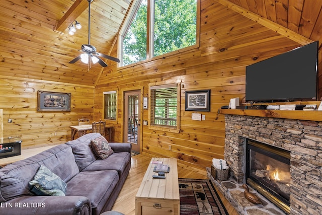 4110 Kidds Way Unit 6, Gatlinburg, TN 37738 - living area with a stone fireplace, a ceiling fan, hardwood / wood-style flooring, high vaulted ceiling, and wooden walls