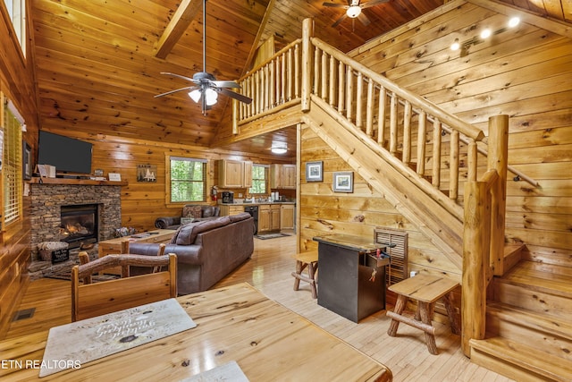 4110 Kidds Way Unit 6, Gatlinburg, TN 37738 - living area with ceiling fan, a wood ceiling with exposed beams, wooden walls, a stone fireplace, and light wood-style flooring