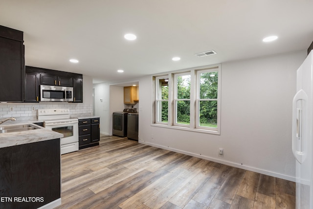 210 Conifer Rd, Winfield, TN 37892 - kitchen with stainless steel microwave, electric range, washer and dryer, light wood finished floors, and light countertops