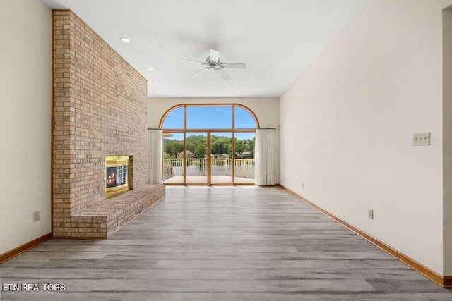136 Oostagala Dr, Loudon, TN 37774 - unfurnished living room with ceiling fan, wood finished floors, a fireplace, recessed lighting, and a water view