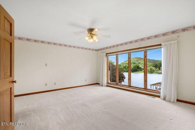 136 Oostagala Dr, Loudon, TN 37774 - spare room featuring light carpet, a ceiling fan, and a water view