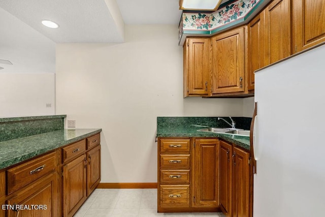136 Oostagala Dr, Loudon, TN 37774 - kitchen featuring freestanding refrigerator, dark countertops, and brown cabinets