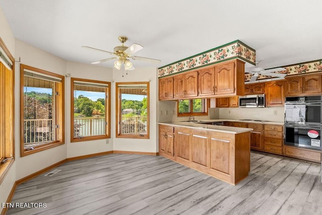 136 Oostagala Dr, Loudon, TN 37774 - kitchen with stainless steel microwave, multiple ovens, light wood finished floors, and a peninsula