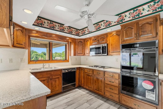 136 Oostagala Dr, Loudon, TN 37774 - kitchen with stainless steel appliances, a ceiling fan, brown cabinets, light wood finished floors, and tasteful backsplash