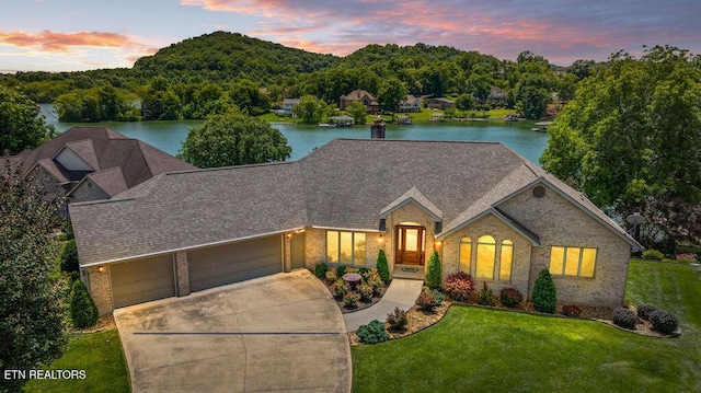 136 Oostagala Dr, Loudon, TN 37774 - view of front facade with brick siding, a front yard, an attached garage, and a water view