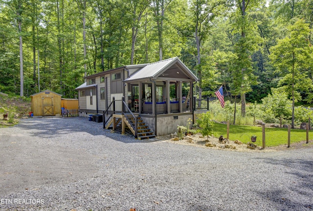 1429 Alpine Dr, Sevierville, TN 37876 - view of front of home with a storage shed, covered porch, board and batten siding, a metal roof, and driveway