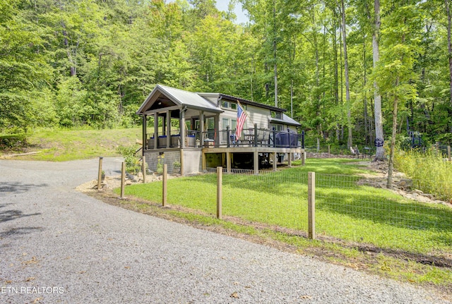 1429 Alpine Dr, Sevierville, TN 37876 - view of front of house with a forest view, a wooden deck, gravel driveway, and a metal roof