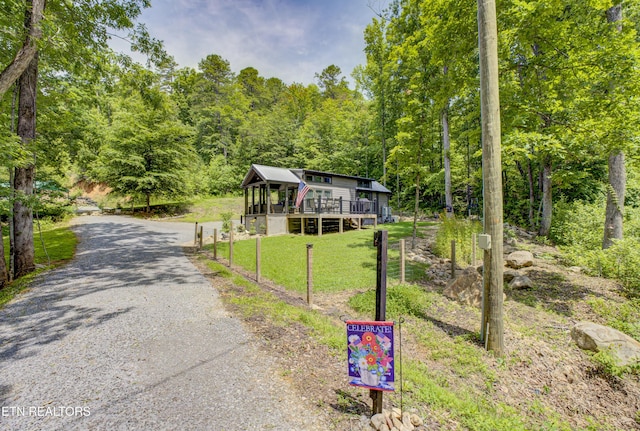 1429 Alpine Dr, Sevierville, TN 37876 - view of front of property featuring gravel driveway, a deck, a view of trees, and a front yard